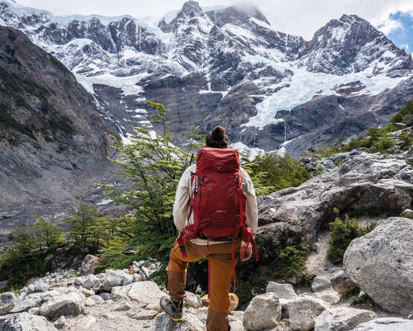 Viajero solitario en el Parque Nacional Torres del Paine sentado en un mirador, reflexionando en silencio mientras admira el Mirador Británico y sus glaciares.