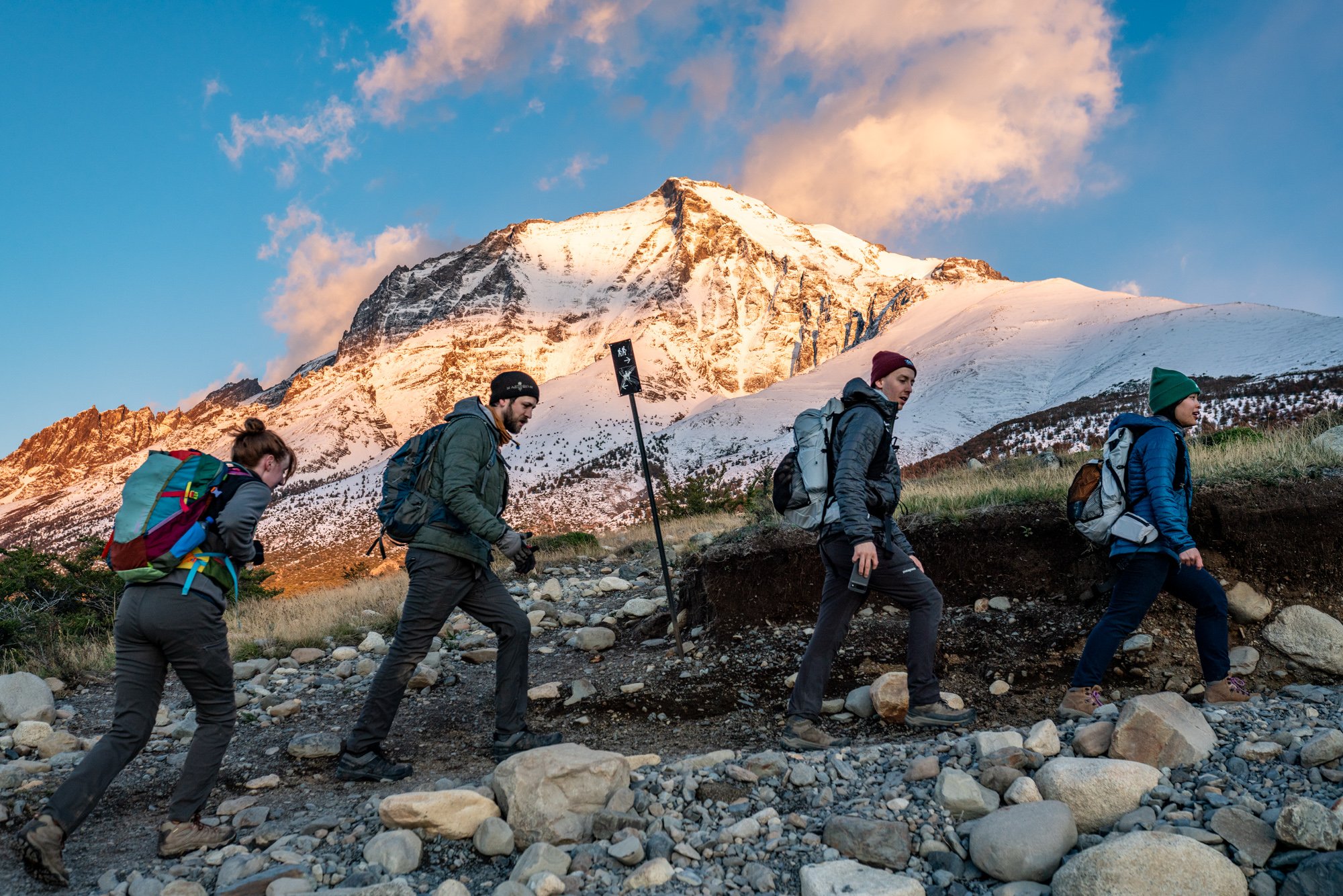 Hikers on the trail to Base Torres Viewpoint in Torres del Paine National Park, Chile, with granite towers rising above the Patagonian landscape.