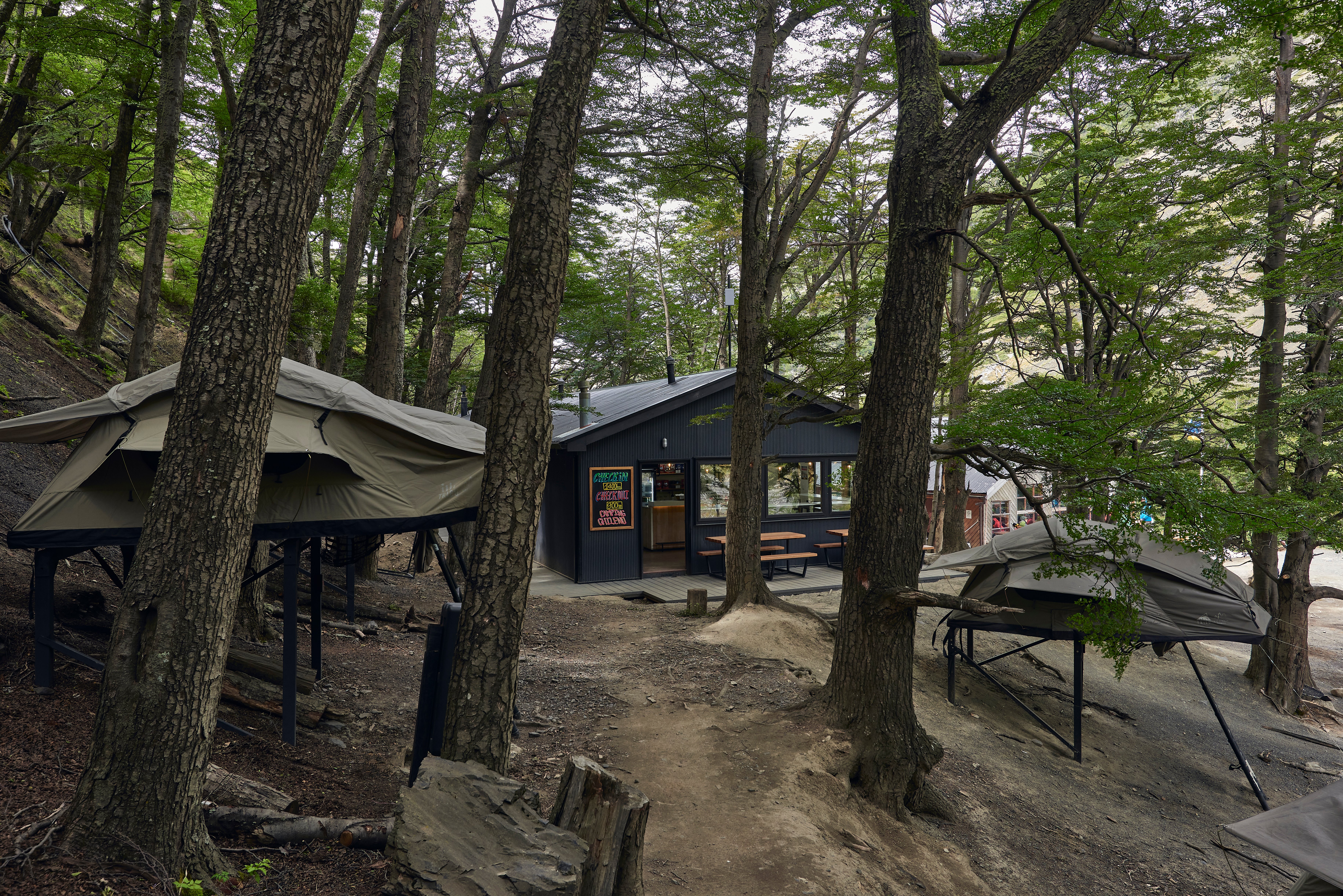 Image highlights lodging options inside Torres National Park, including Chileno sector campground near Base Torres Viewpoint. Features café, bathrooms, showers, and elevated or ground tents with full amenities. Staying here allows hikers to recharge overnight, enjoy breakfast, and start early for the full-day hike to Base Torres, one of the world’s most iconic geological wonders.